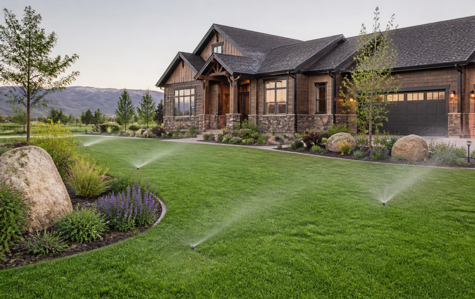 Finished residential landscape with irrigation running at golden hour